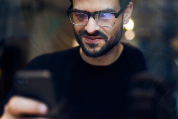 Serious ethnic man browsing smartphone