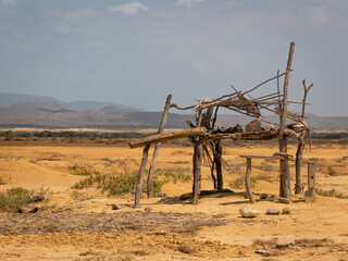 Fototapeta na wymiar Some Logs Built in a Desert Near a Bay in Bahia Honda, La Guajira, Colombia