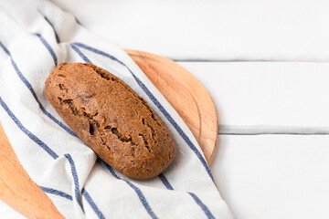 Dark sourdough einkorn bread on white wooden table with space for text