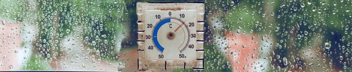 A thermometer glued to the window to determine the temperature of the environment. Panoramic photography. Selective soft focus