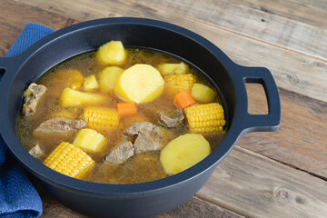 Freshly made Sancocho in a pot on a wooden base. Copy space.