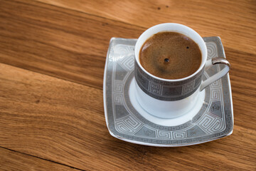 A cup of Traditional Turkish Coffee with wooden background.