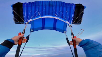 Blue parachute. Skydiver's point of view. - obrazy, fototapety, plakaty