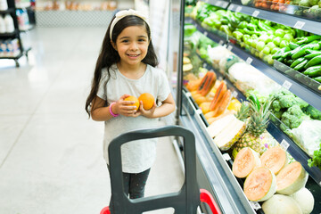 Adorable daughter helping mom to choose oranges
