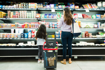 Young woman and little girl deciding food brands