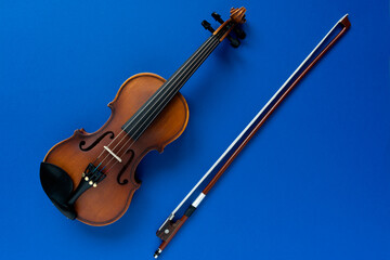 Fototapeta na wymiar Violin and bow on a blue background