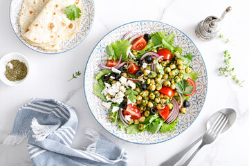 Mediterranean Greek and chickpea salad with fresh vegetables and feta cheese, top view