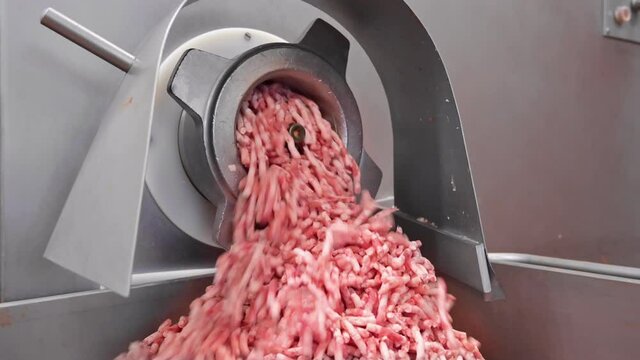 Making Minced Meat In An Electric Meat Grinder From Fresh Beef At The Meat Processing Plant. Mincer Machine With Fresh Chopped Meat. High Quality 4k Footage