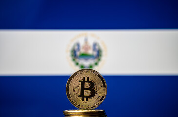 Bitcoin representation coin placed in front of blurred Salvador's national flag. El Salvador is the...