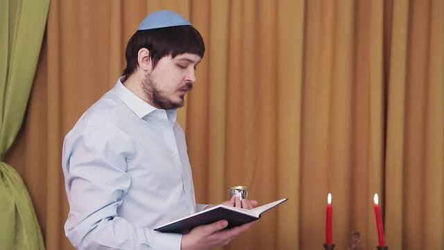 Before the chuppah ceremony, the Jewish groom reads prayers and psalms for siddur in the synagogue hall and makes kiddush for wine