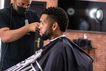 barber cutting hair for young people. in barber shop for all ages and styles.