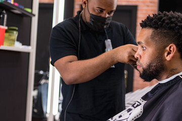 barber cutting hair for young people. in barber shop for all ages and styles.