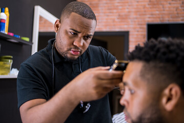 hairdresser cutting hair to young man. in barber shop for all ages and styles. shaping hair cut .