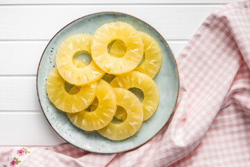 Canned sliced pineapple fruit on plate.
