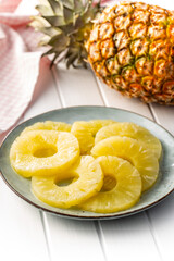 Canned sliced pineapple fruit on plate.