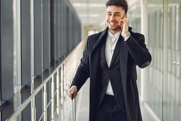 Elegant man at the airport with a suitcase