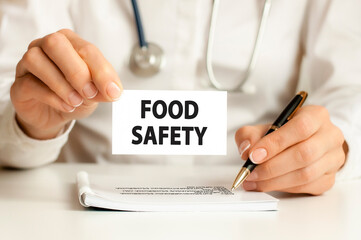doctor holding card in hand with words food safety, medical concept