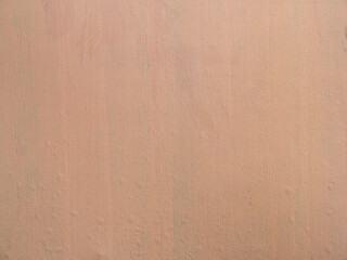 The texture of a beige iron garage wall. Metal background with new, fresh paint on top of rust. Detailed photo of paint defects, air bubbles.