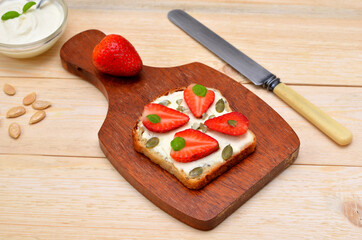 vegetarian sweet toast with strawberries on a board and a knife
