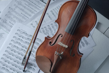 Plakat Close up detail on violin body, bow and music notes background. Classic instrument with copy space area 