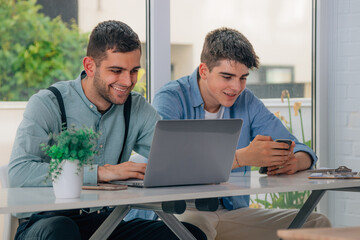 young people with computers and mobile phones at their desks