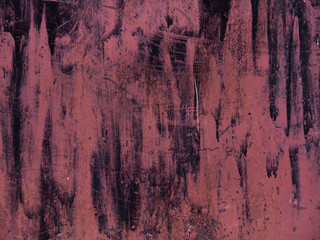 Detailed image of an iron garage wall. The texture of peeling pink, black and crimson paint from the metal sheet. Background of abstract, chaotic spots and scratches of various shades.
