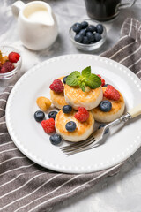Ready cheese cakes with berries on a breakfast plate 