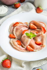 Ready-made dumplings with strawberries on a white plate 