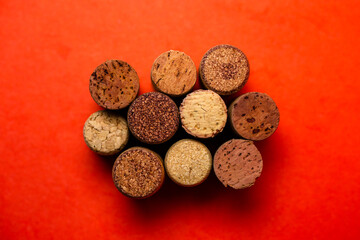 Cork from wine of different kinds on a red background view from above