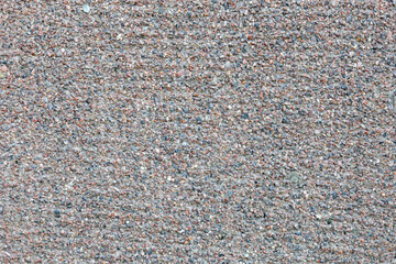 Grunge concrete surface decorated with small pebbles. Small stones wall texture for background usage. Rough backdrop. Abstract pattern. Building's facade. Urban design. 
