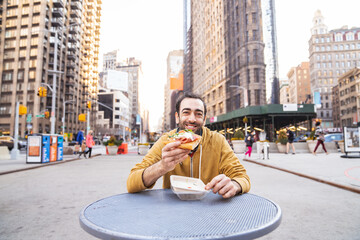 Young man eating pizza snack outdoors
