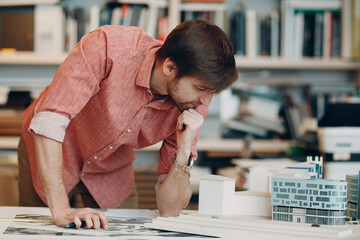 Architect with blueprints and layout design project template on table
