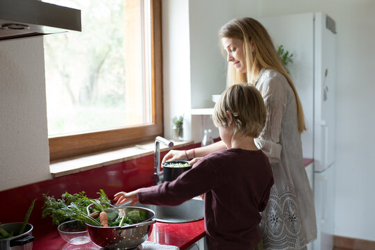 Family preparing a healthy meal in the kitchen at mediterranean home.
