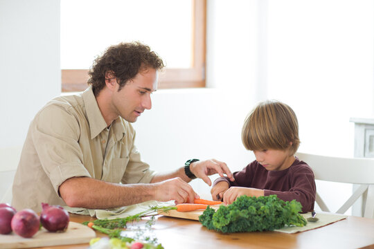 Family preparing a healthy meal in the kitchen at mediterranean home.
