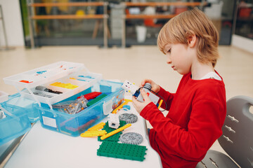 Little boy with robotic constructor assembling technical toy. Children Robotics constructor robot
