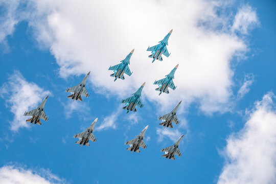 Moscow, Russia - May, 05, 2021: Fighters Su-35S and Su-30SM with bombers Su-34 in the blue sky over Red Square in the group Tactical Wing. Aviation part of Victory parade in Moscow