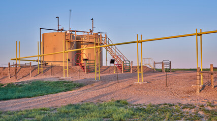 oil extraction facility with a crude oil tanks in a green prairie, Pawnee National Grassland in Colorado
