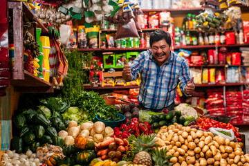 Successful man showing thumbs up, in a grocery store of Guatemala with a variety of food ítems.