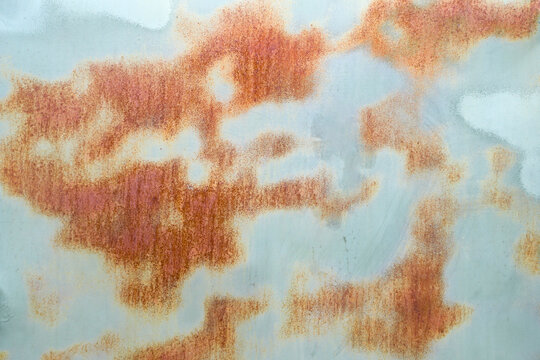 Texture of an old, stained and rusty metal side of the military vehicle once painted for the camouflage effect