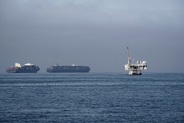 Ocean seascape with cargo ships and oil platform