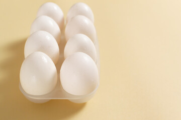 White chicken eggs lie in an egg tray.