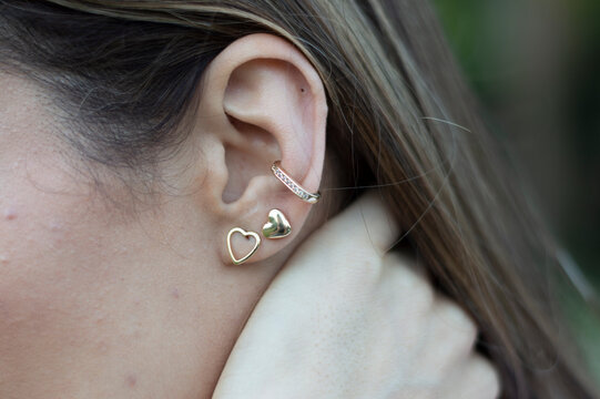 Woman wearing earrings.  Earrings at the ear of young woman, women's accessories, gold earrings