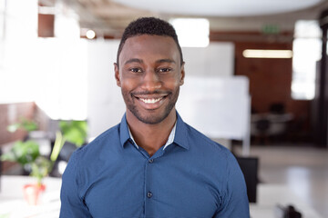 Portrait of african american businessman standing in office smiling to camera
