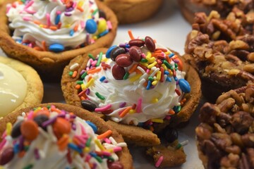 Unique cupcake assortment with toppings of sprinkles, nuts and candy
