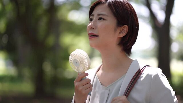 ハンディファンを使う女性