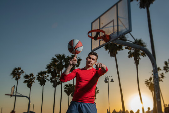 Basketball street player with basketball ball outdoor. Hand spinning basket ball. Balancing basketball on finger.