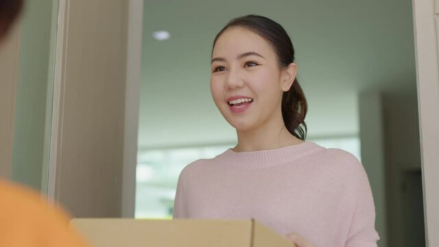 Asia people female girl success pickup free fast express good postal post mail support from e-shopping retail order online e-commerce store postmate worker carry container at door home city life.