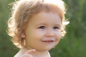 Kids portrait, close up head of cute Baby in green nature park. Kids smiling, cute smile.