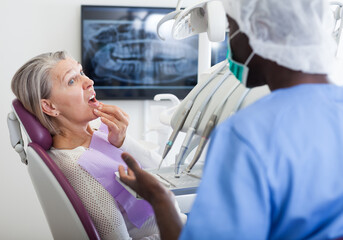 Fototapeta premium Professional positive doctor man talking with patient in medical chair. High quality photo