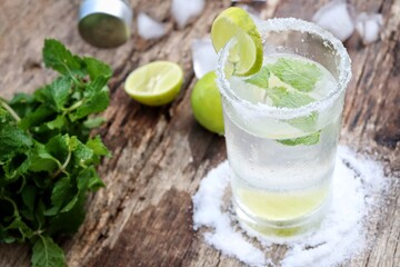 Making a margarita cocktail lime salt and mint leaves